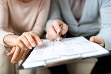 Deux personnes remplissant des papiers administratifs sur un presse-papiers