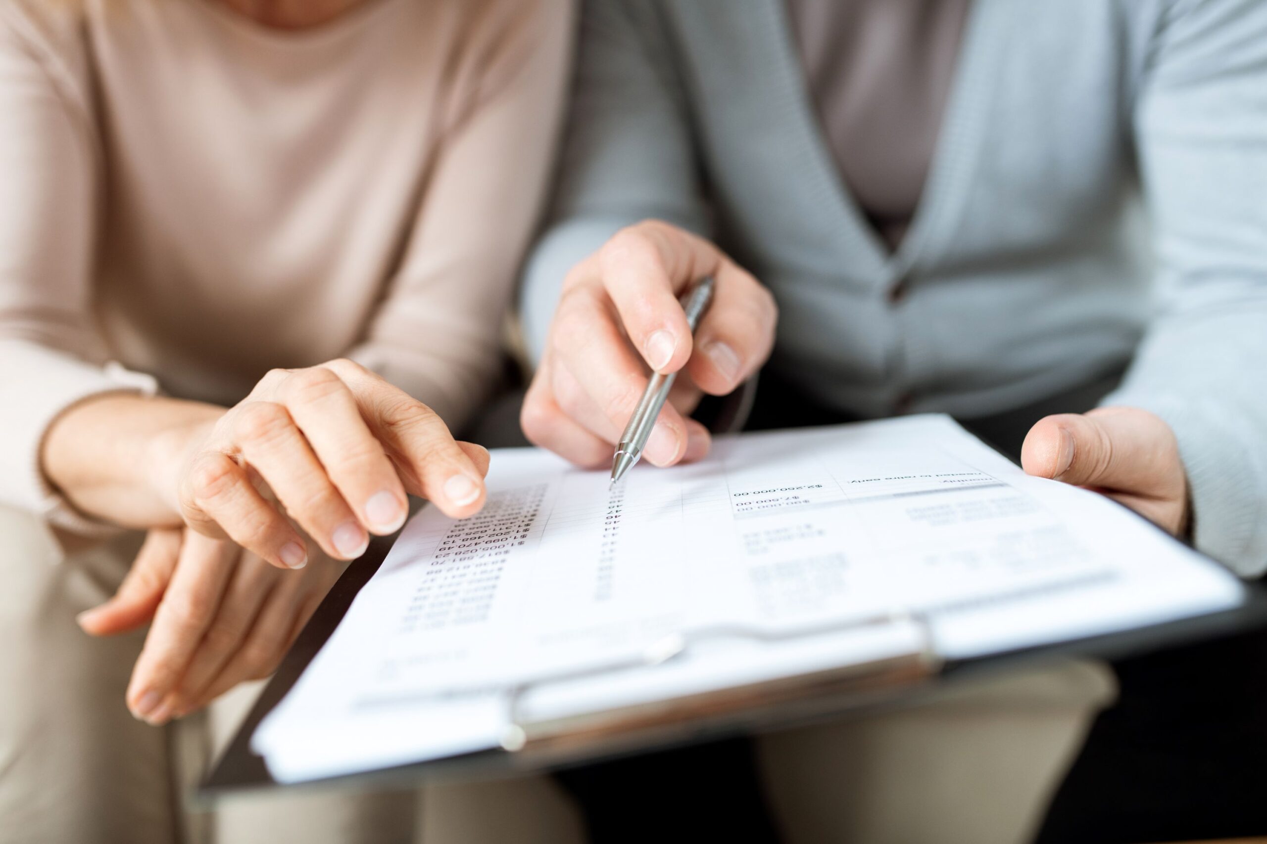 Deux personnes remplissant des papiers administratifs sur un presse-papiers