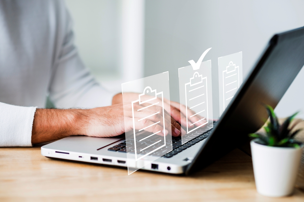 Un homme sur son ordinateur rempli une checklist matérialisée sous forme de hologramme