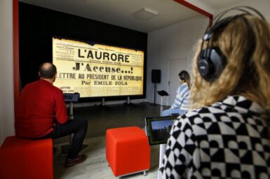 Des habitants au cœur de la Micro-Folie regardent une vidéo informative