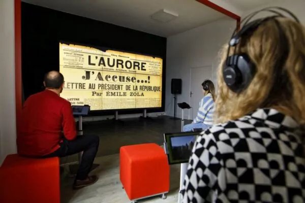 Des habitants au cœur de la Micro-Folie regardent une vidéo informative