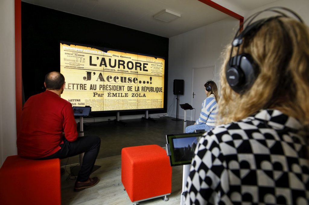 Des habitants au cœur de la Micro-Folie regardent une vidéo informative