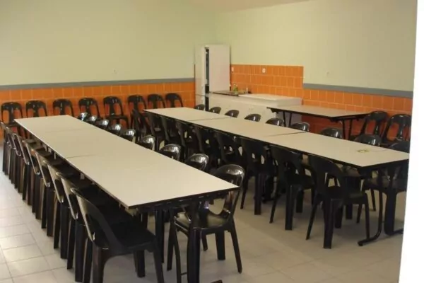 Intérieur de la salle du Stade au Marillais avec frigo et évier dans le fond