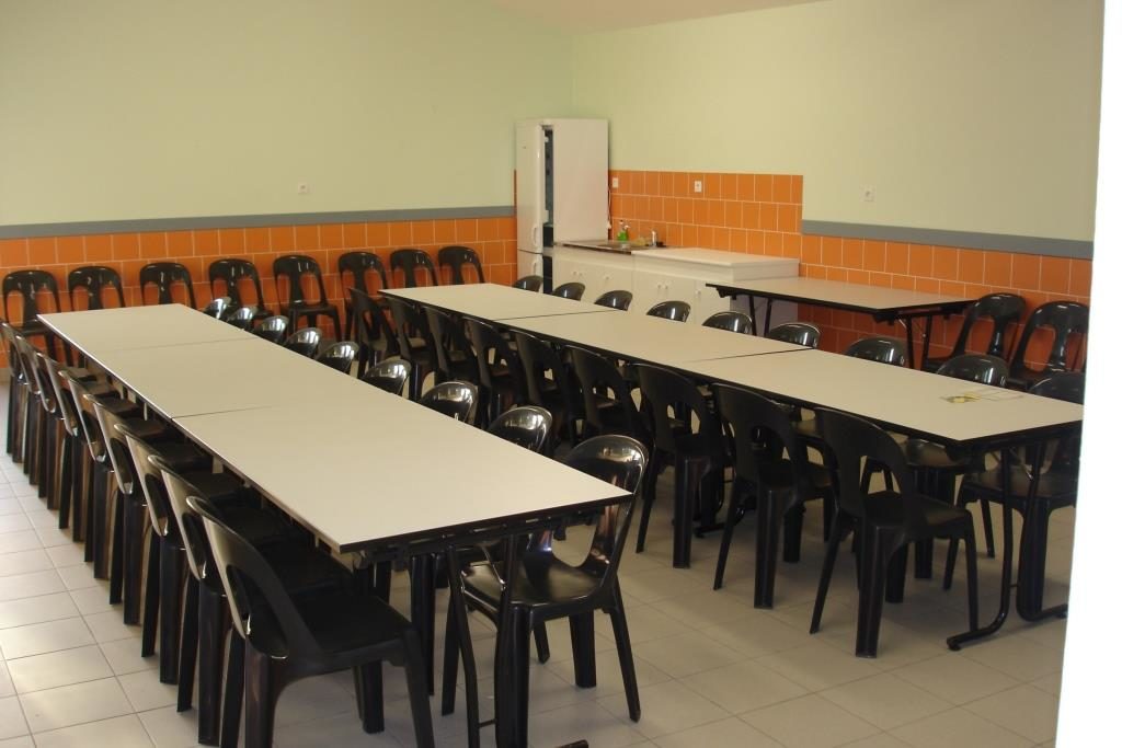 Intérieur de la salle du Stade au Marillais avec frigo et évier dans le fond