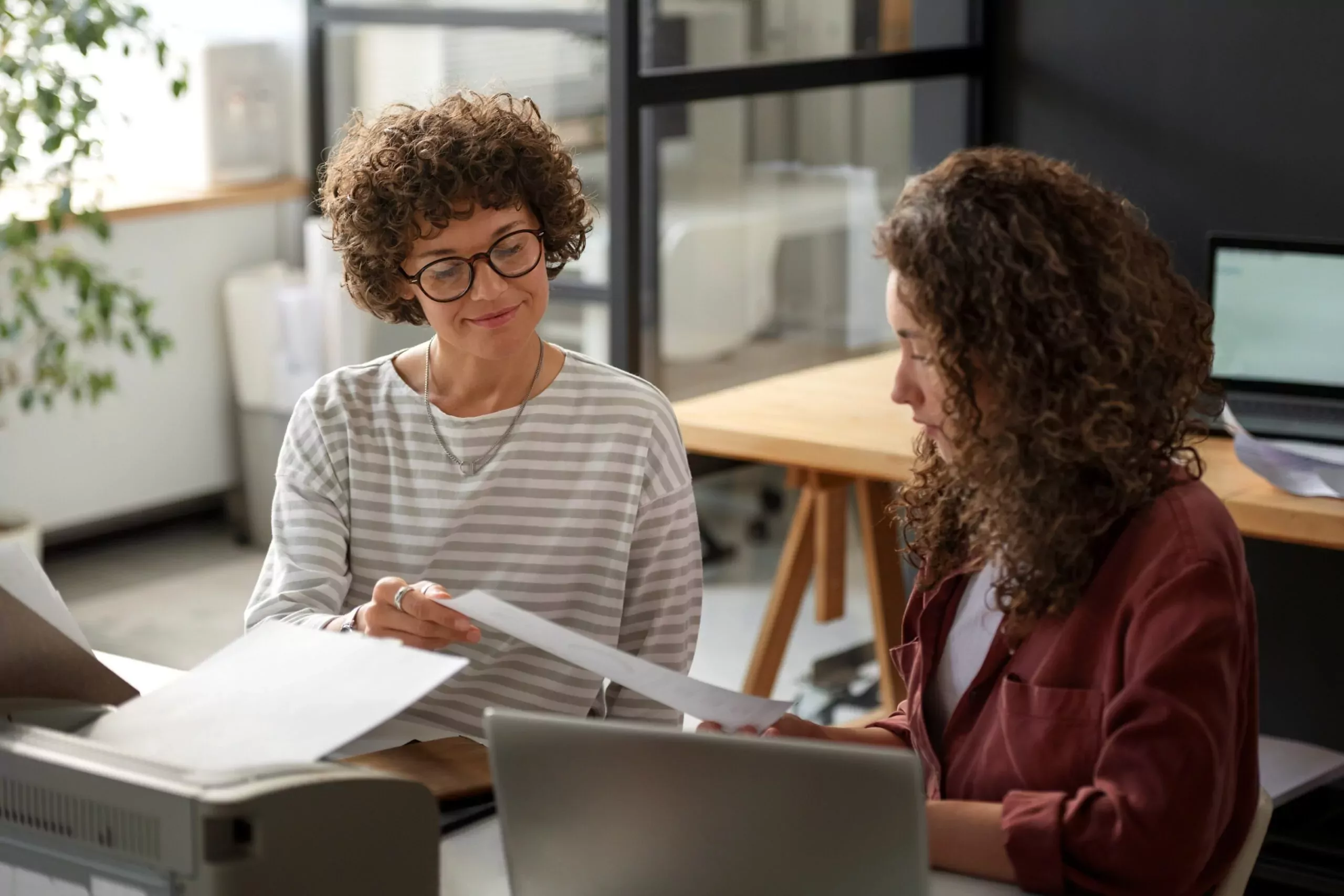 Deux femmes discutent à un bureau