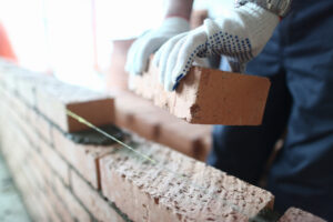 un maçon qui pose une brique