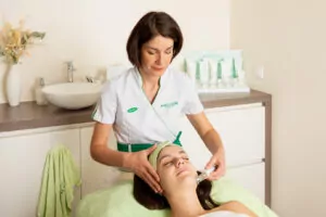 Une employée de Douceur et Bien-Être fait un soin du visage à une cliente