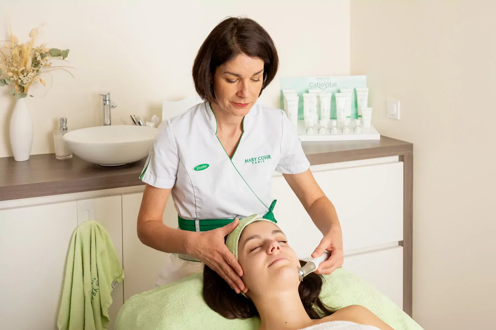 Une employée de Douceur et Bien-Être fait un soin du visage à une cliente