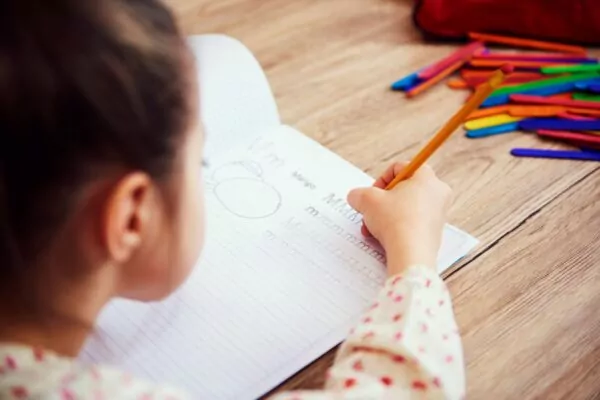 Gros plan d'une enfant en train de faire ses devoirs