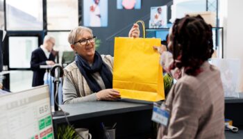 Une femme passe en caisse d'un magasin