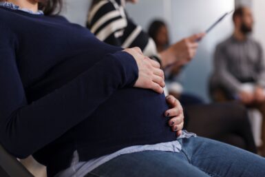 Une femme enceinte tient son ventre rond