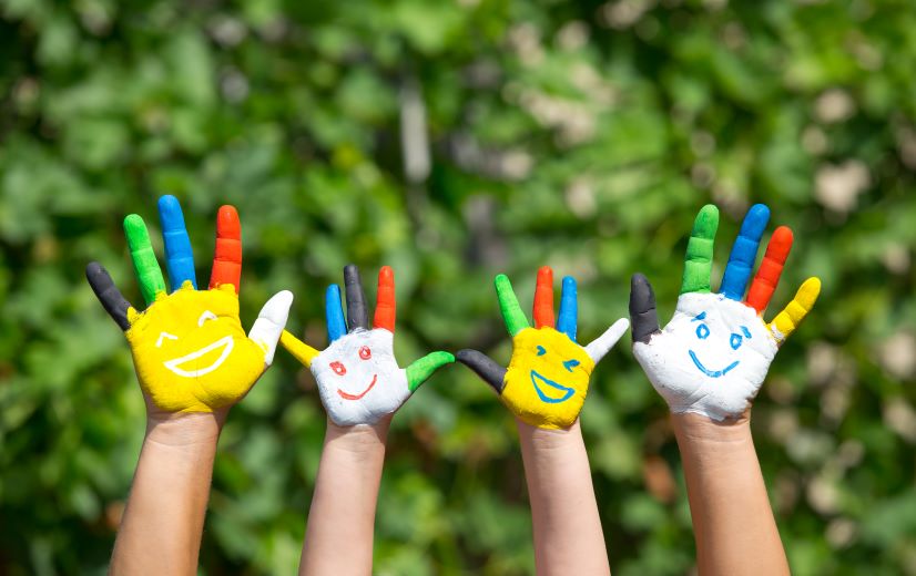 Mains d'enfants et d'adultes colorées et peintes avec des visages avec le sourire. Relais Petite Enfance