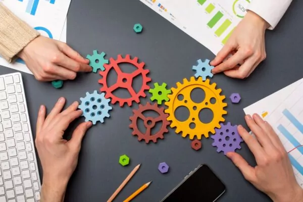 Des mains assemblent des engrenages