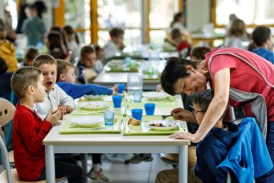 Dans un restaurant scolaire des enfants sont assis à table