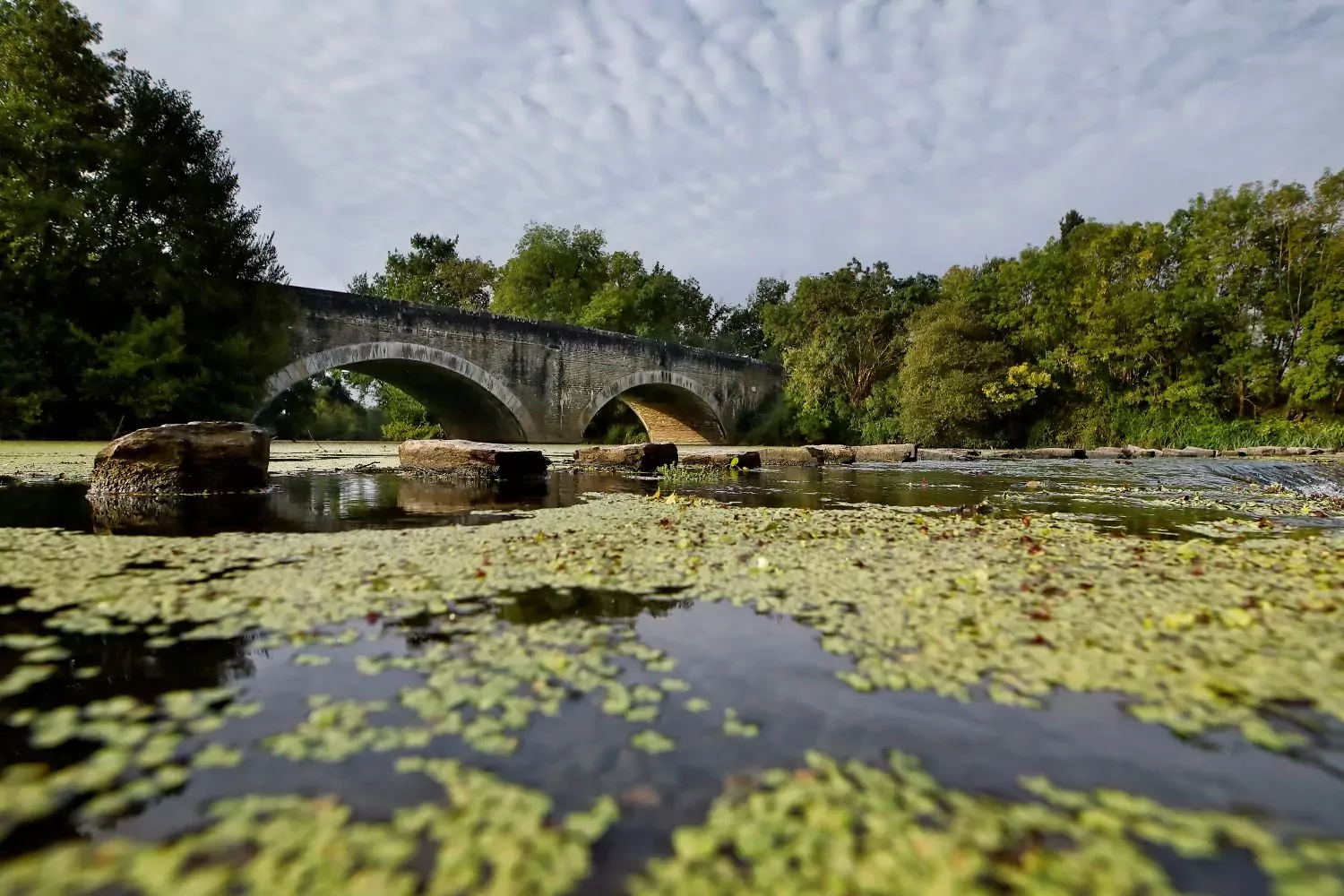 un pont en pierre au dessus d'une étendue d'eau