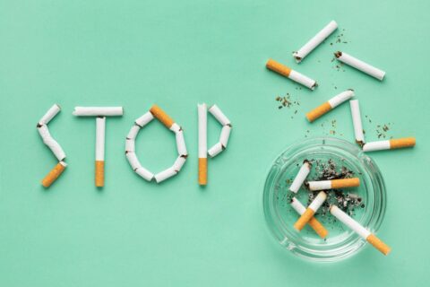 Image avec des cigarette formant le mot stop, à droite du mot un cendrier avec des cigarette entamé