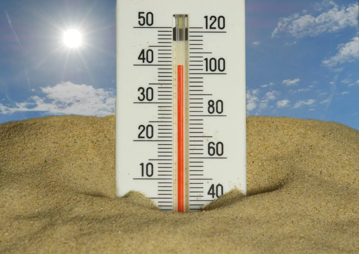 Un thermomètre montrant une température très haute avec un soleil en haut à gauche.